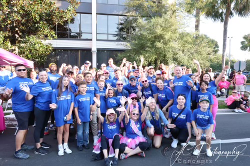 Hillpointe employees gathered in matching shirts at the Making Strides Against Breast Cancer Walk at Lake Eola Park, showing unity and support for cancer research and awareness